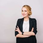 Joyful confident blonde businesswoman in suit smiling to camera isolated on white background. Modern worker, secretary, executive, successful, cheerful mood. Place for text